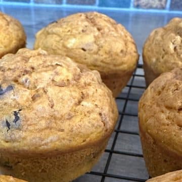 Freshly baked pumpkin chocolate chip muffins cooling on a wire rack.