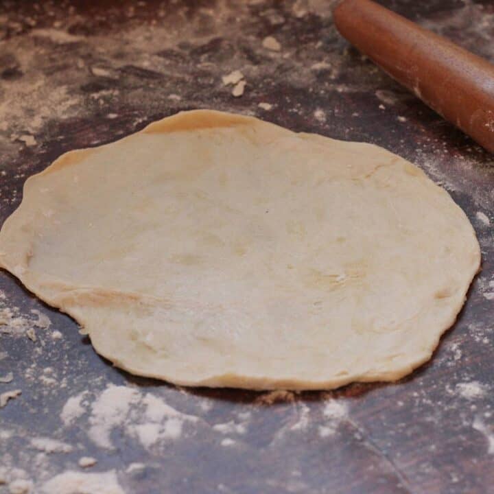 Rolling out sourdough discard tortillas.