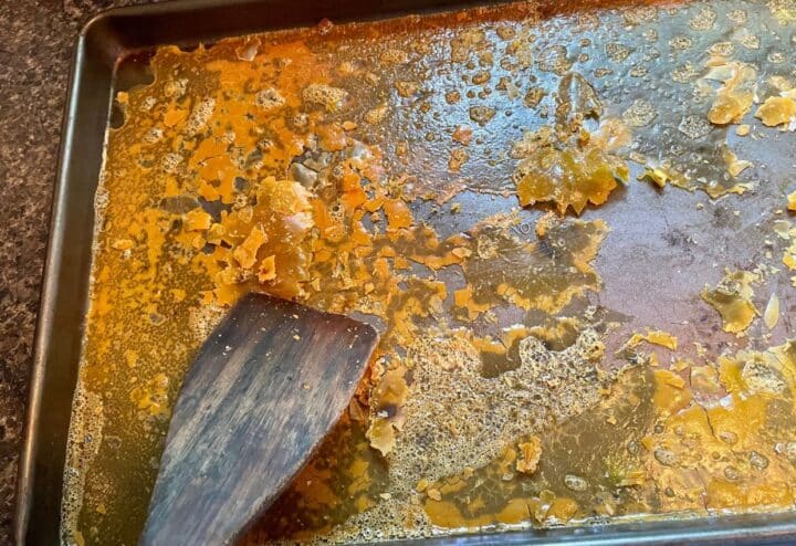 Scraping dehydrated eggs off pan.