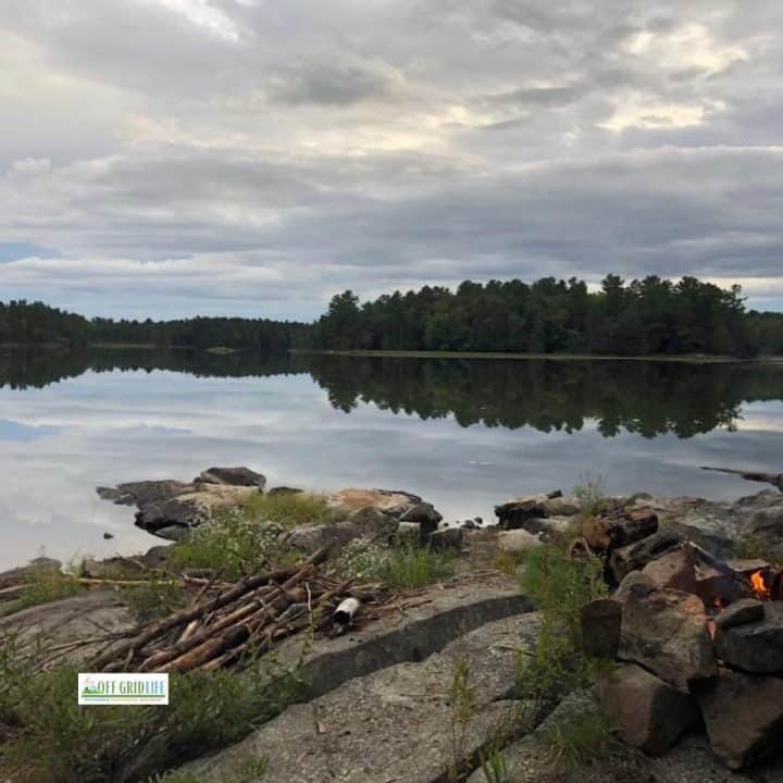 Campfire built on a rocky lake shore.