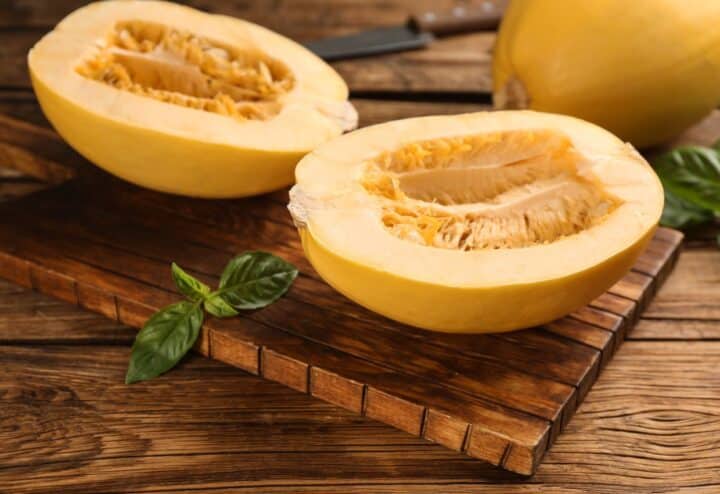 Two slices of squash on a wooden cutting board.