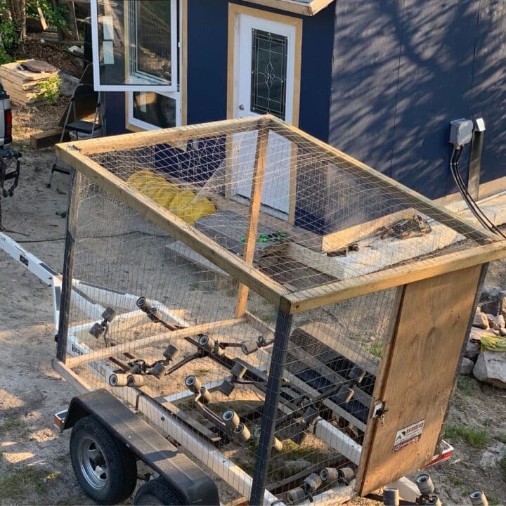 A chicken coop on a trailer in front of a house.