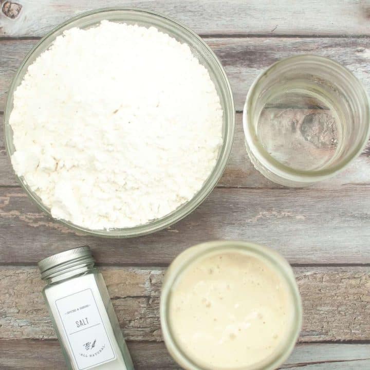 Ingredients for artisan dutch oven sourdough bread recipe on a wooden table.