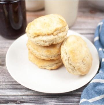 Sourdough Discard Biscuits stacked on plate with blue cloth napkin.