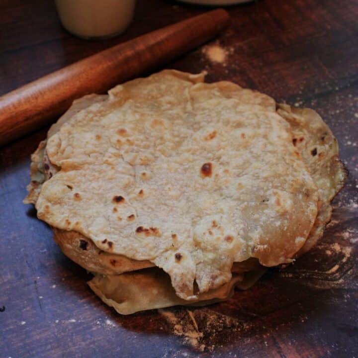Sourdough Discard Tortillas on counter with wooden rolling pin.