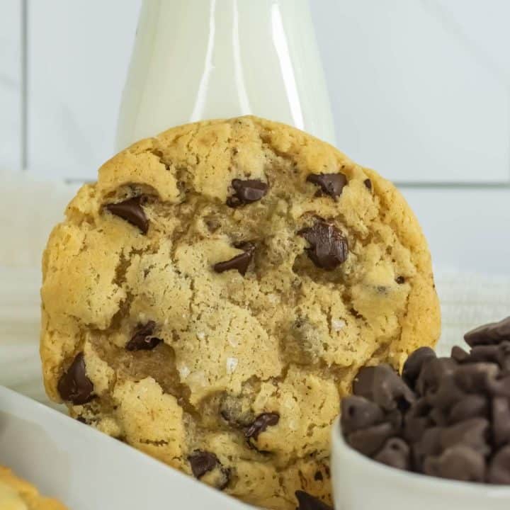 A sourdough discard chocolate chip cookie with a bottle of milk.
