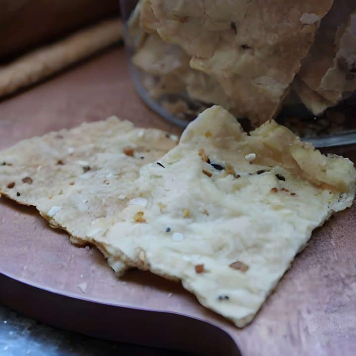 Sourdough discard crackers on a wooden cutting board.