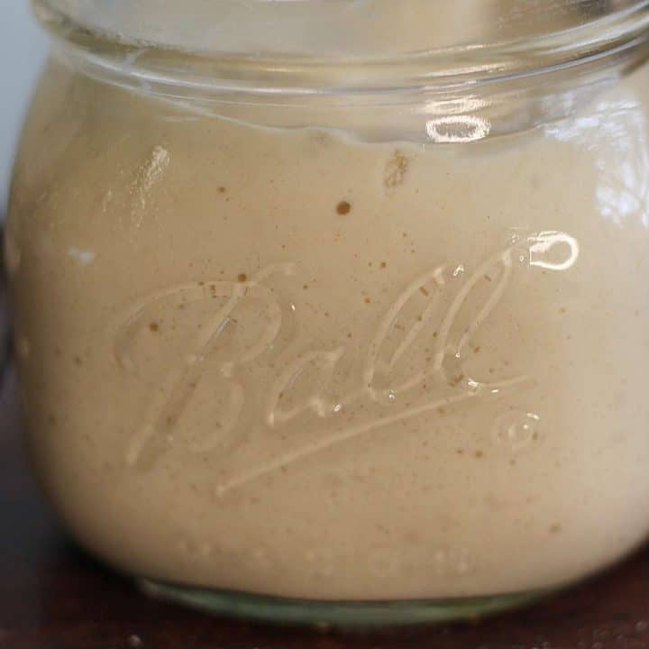 A glass jar containing a starter, perfect for sourdough discard recipes.