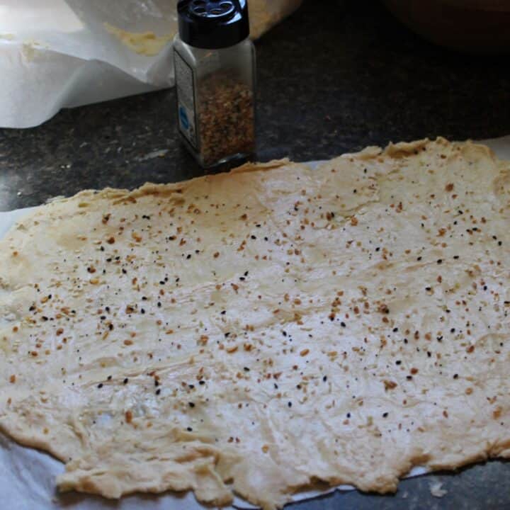 Sprinkling seasoning on sourdough discard crackers before baking