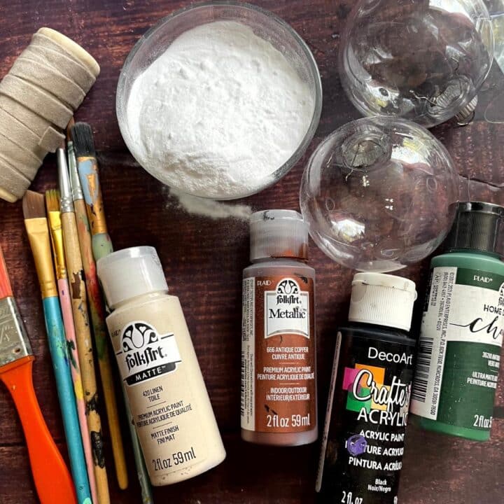 A table with paint, paintbrushes, and other supplies.