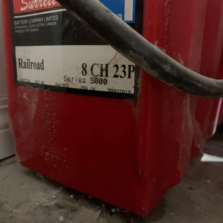 A red Surette battery, part of a battery bank for an off grid power system.