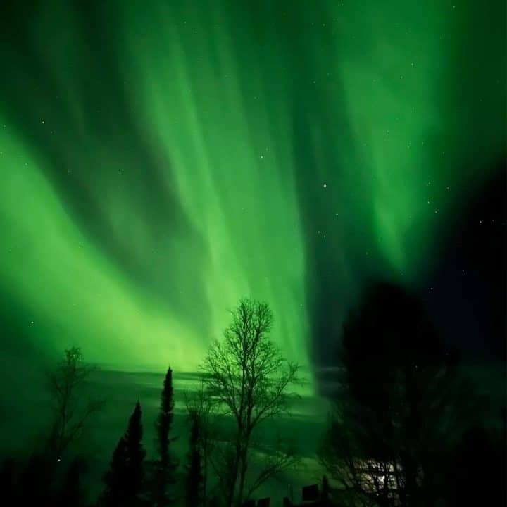 A green aurora bore lights up the sky over an off the grid cabin in Canada's Northwest Territories.