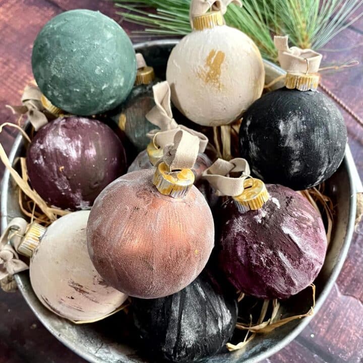 Christmas ornaments in a bucket with pine cones.