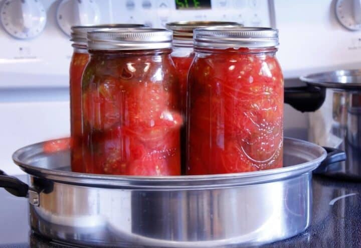 Water bath canning four jars of tomatoes.