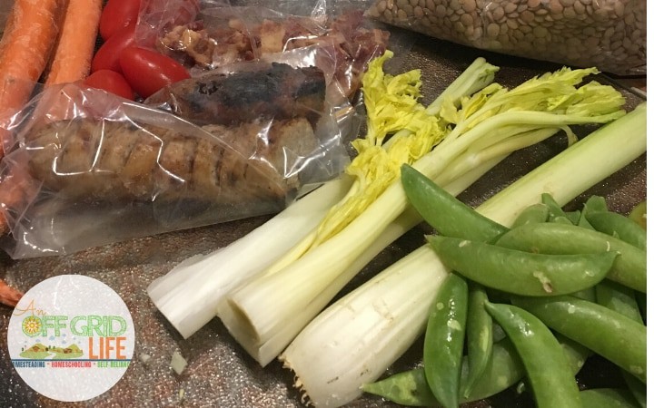 A variety of vegetables are sitting on a table, including kale.