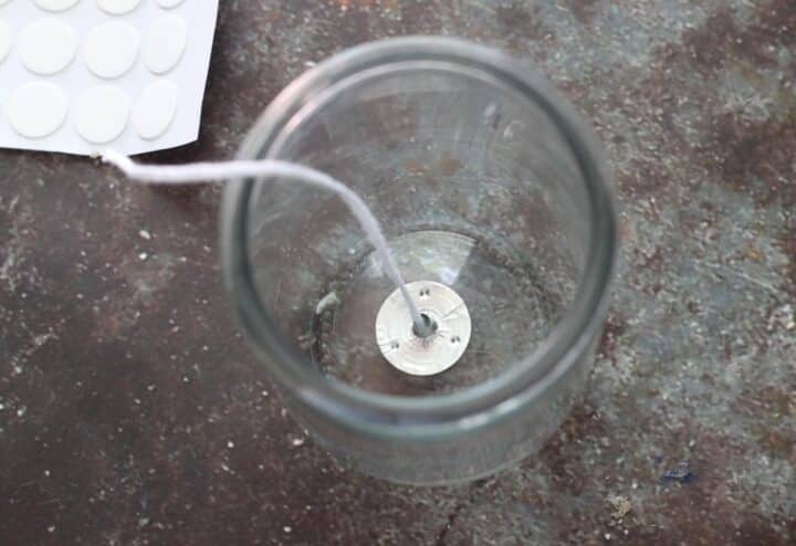 A glass jar with a white cord on it.