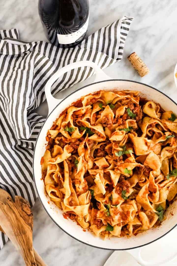 bolognese sauce over wide noodles in pot