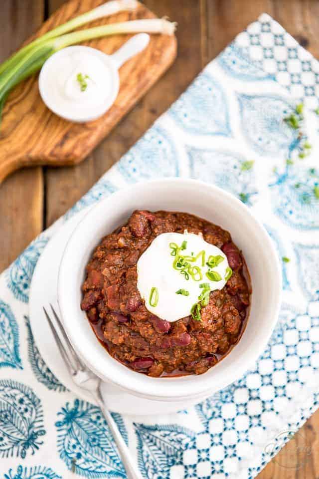 chili con carne in white bowl with sour cream