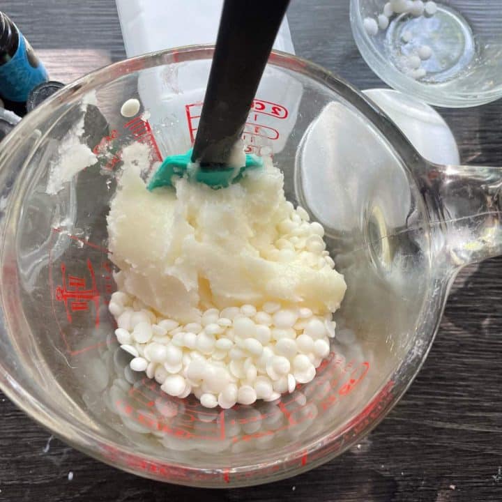 A measuring cup filled with white powder and a black spatula.