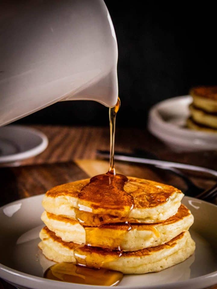 old fashioned buttermilk pancakes with syrup drizzled on top
