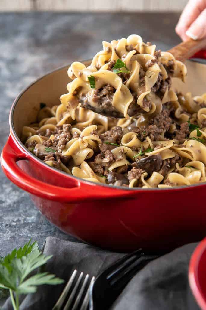 beef stroganoff being lifted on wooden spoon