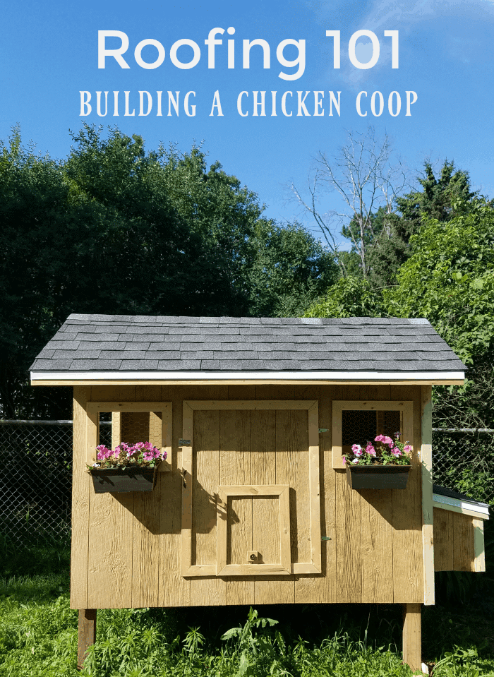 A small wooden DIY chicken coop with a shingled roof and flower boxes, set in a grassy yard with trees and fencing in the background. Text reads "Roofing 101: Building a Chicken Coop.