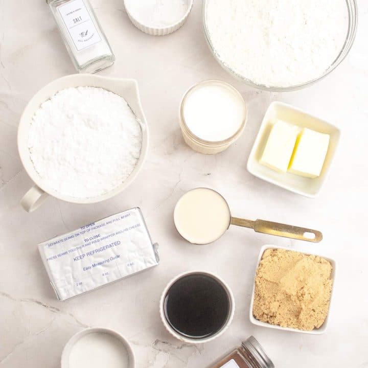 Ingredients for baking sourdough cinnamon rolls recipe arranged on a marble countertop.