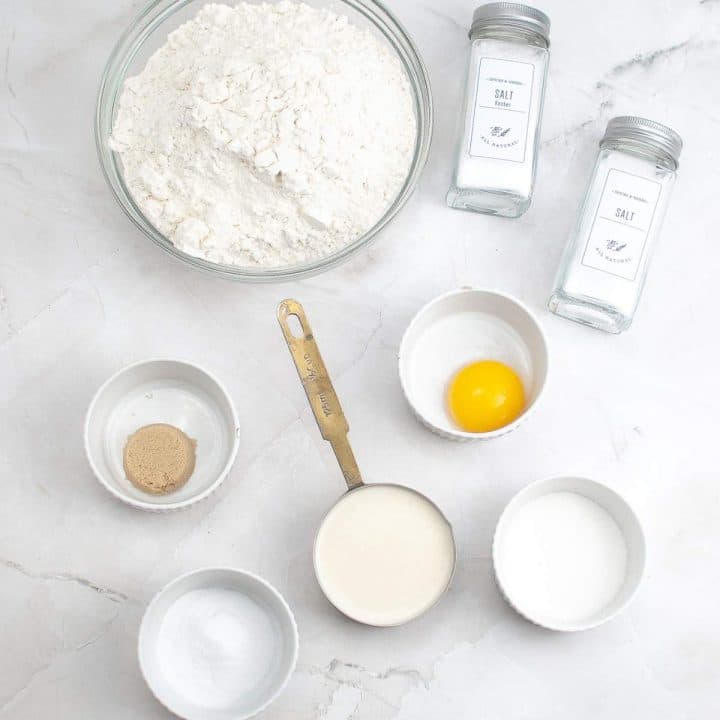 Ingredients for baking neatly arranged on a marble countertop.