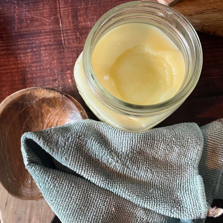 A jar of wood butter on a wooden table.