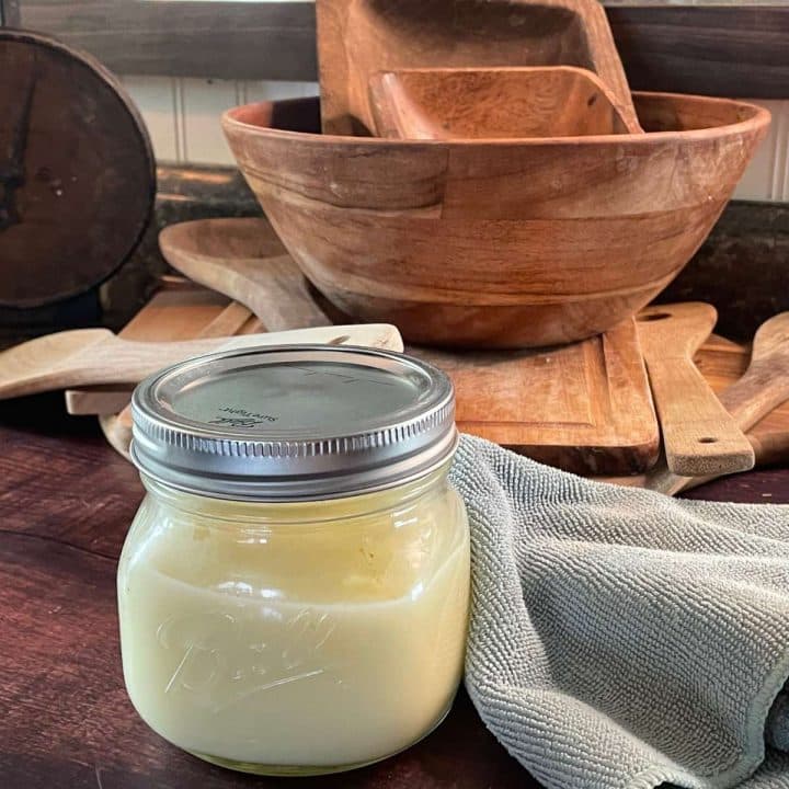 A mason jar of wood butter on a wooden table.