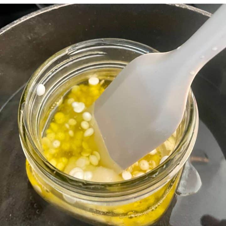 A spoon is stirring into a jar of homemade wood butter.