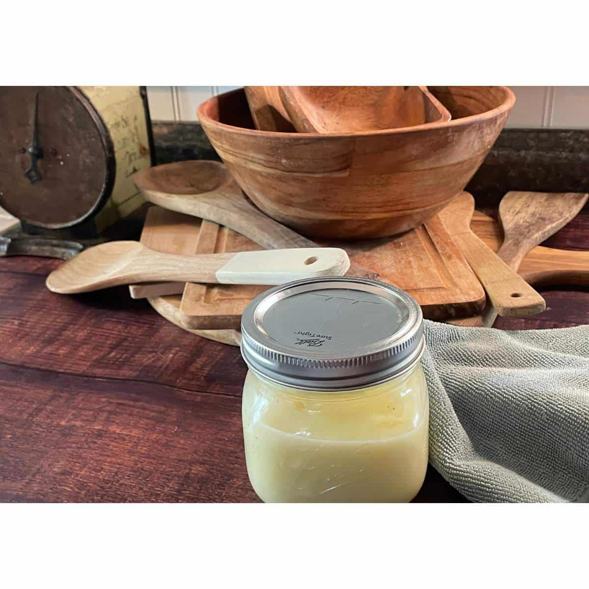 A jar of butter on a wooden table.